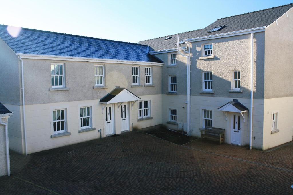 twee gebouwen met witte deuren en een binnenplaats bij 5 Laurel Court in Ulverston