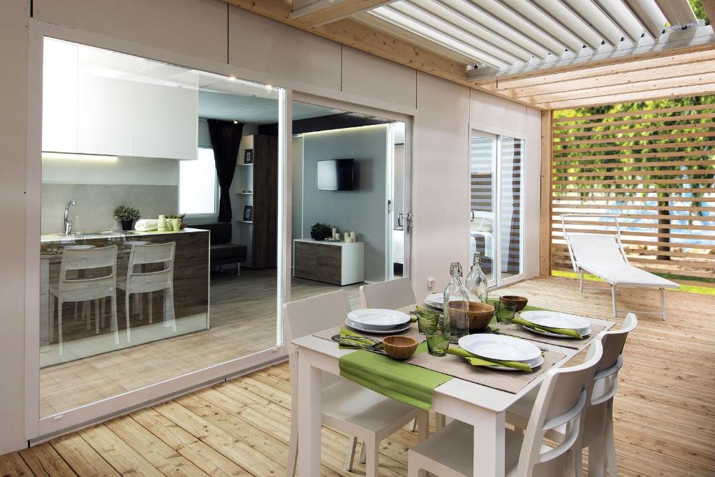 a kitchen and dining room with a table and chairs at Dune Prestige & Chalets in Bibione
