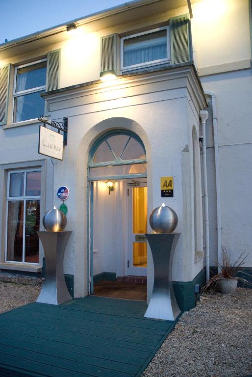 a building with a door with a green rug in front at Fernhill Hotel in Lyme Regis