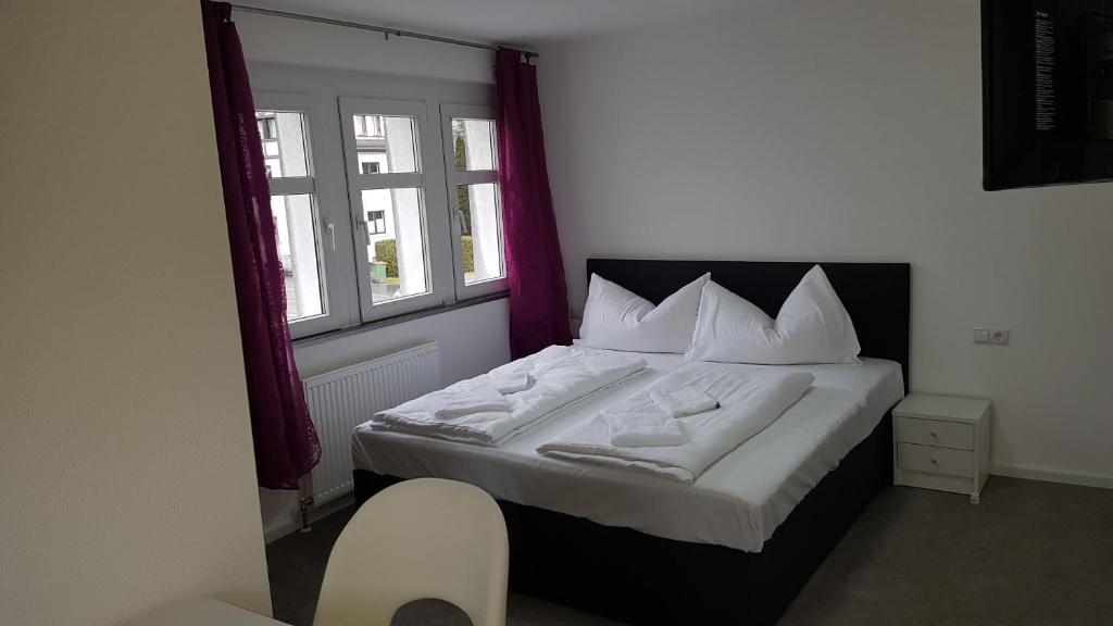 Schlafzimmer mit einem Bett mit weißer Bettwäsche und Kissen in der Unterkunft Gasthaus Sofram in Frastanz