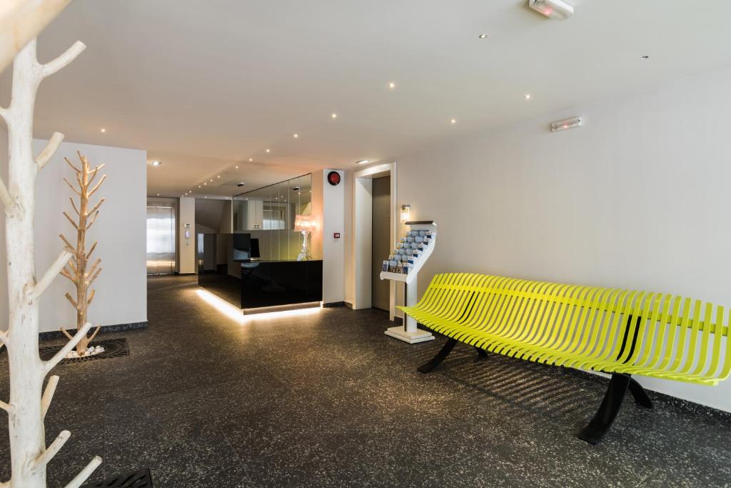 żółtą ławkę w pokoju ze schodami w obiekcie Athens Mosaico Suites & Apartments w Atenach