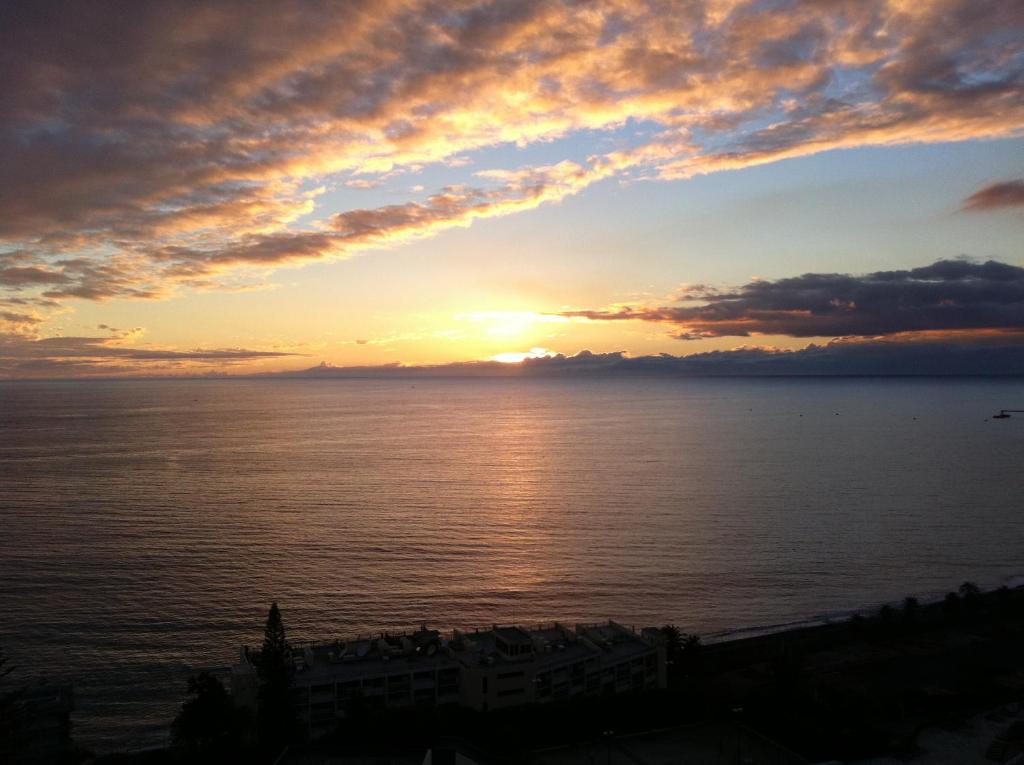 einen Sonnenuntergang über dem Meer mit Sonnenuntergang in der Unterkunft Shearwaters - Sounds of the sea in Funchal