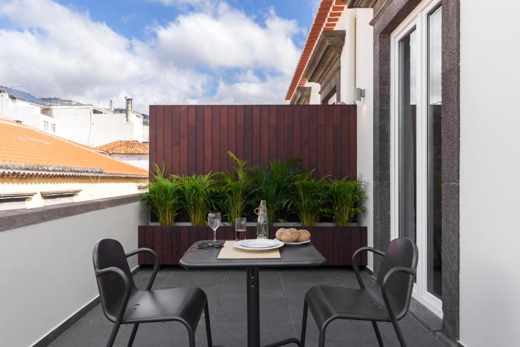 a patio with a table and chairs on a balcony at Downtown Funchal Apartments by An Island Apart in Funchal