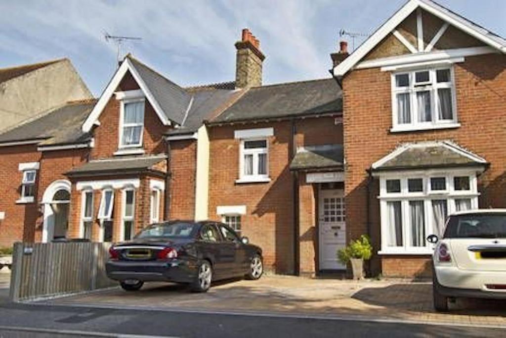 two cars parked in front of a brick house at Endearing Edwardian House in Quaint Deal, Kent in Deal