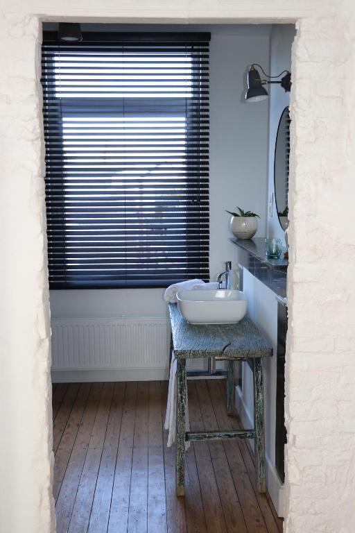 a bathroom with a sink and a window at Mañana Mañana in Antwerp