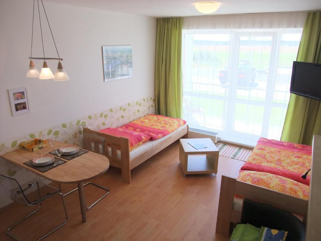 a living room with a bed and a table at Apartmán u Aurory in Třeboň