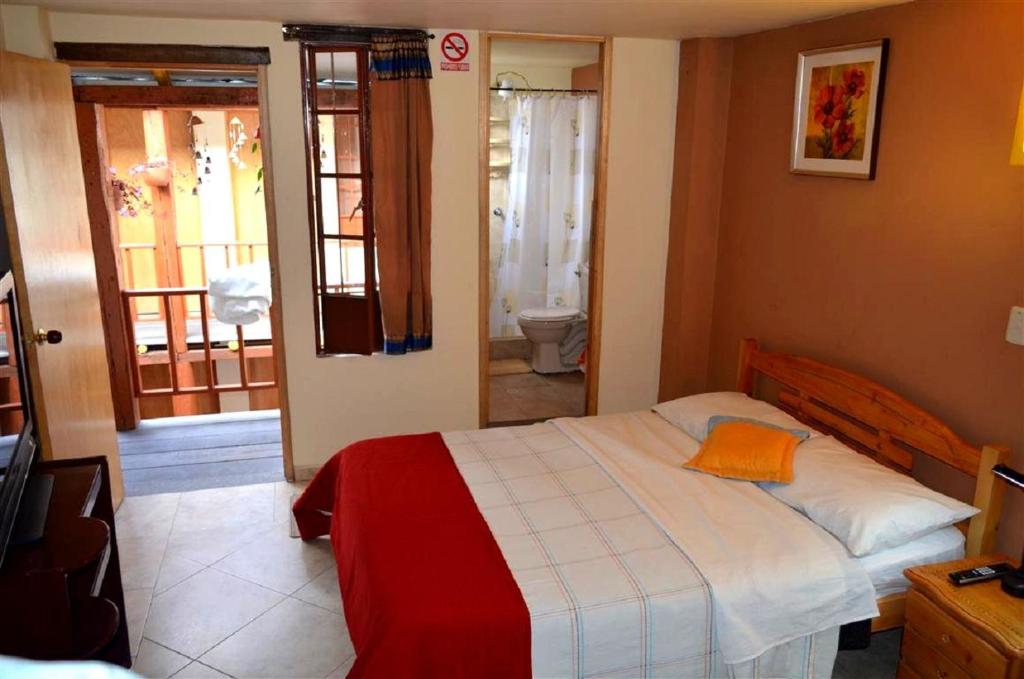 Postel nebo postele na pokoji v ubytování Hostal La Candelaria