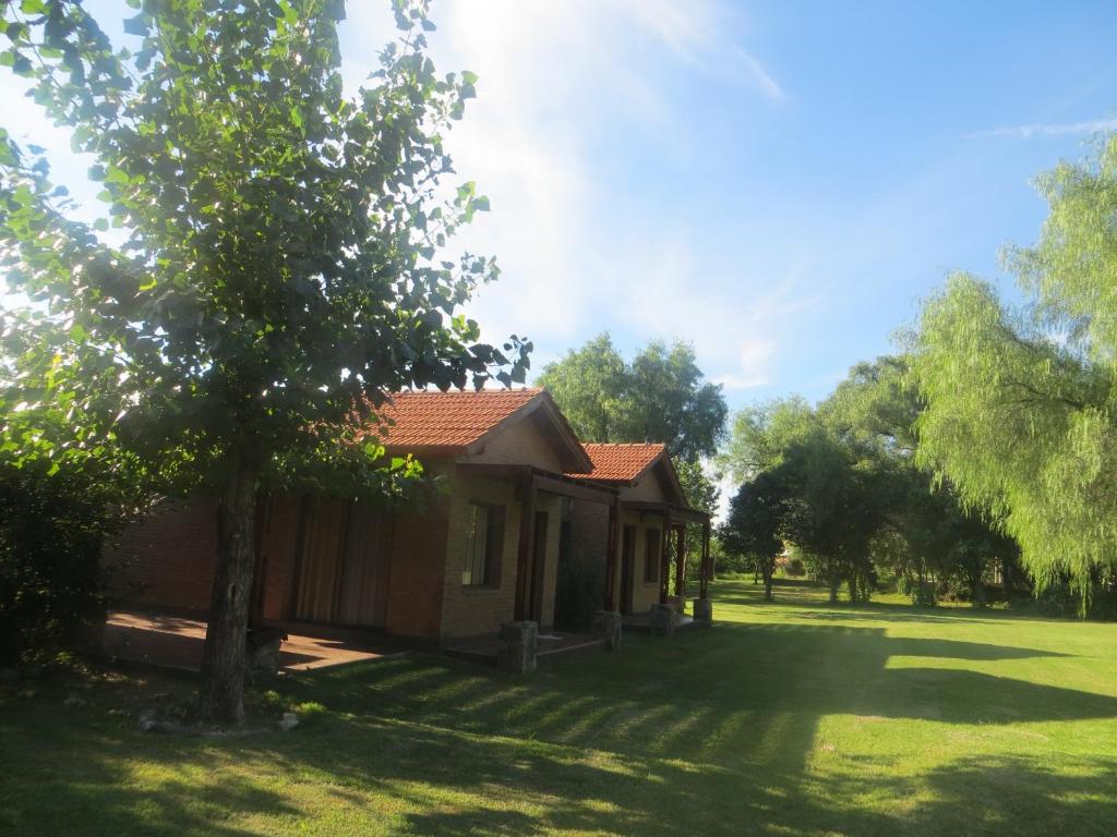 a small house in a field with a tree at Reina de las Cortaderas in Merlo