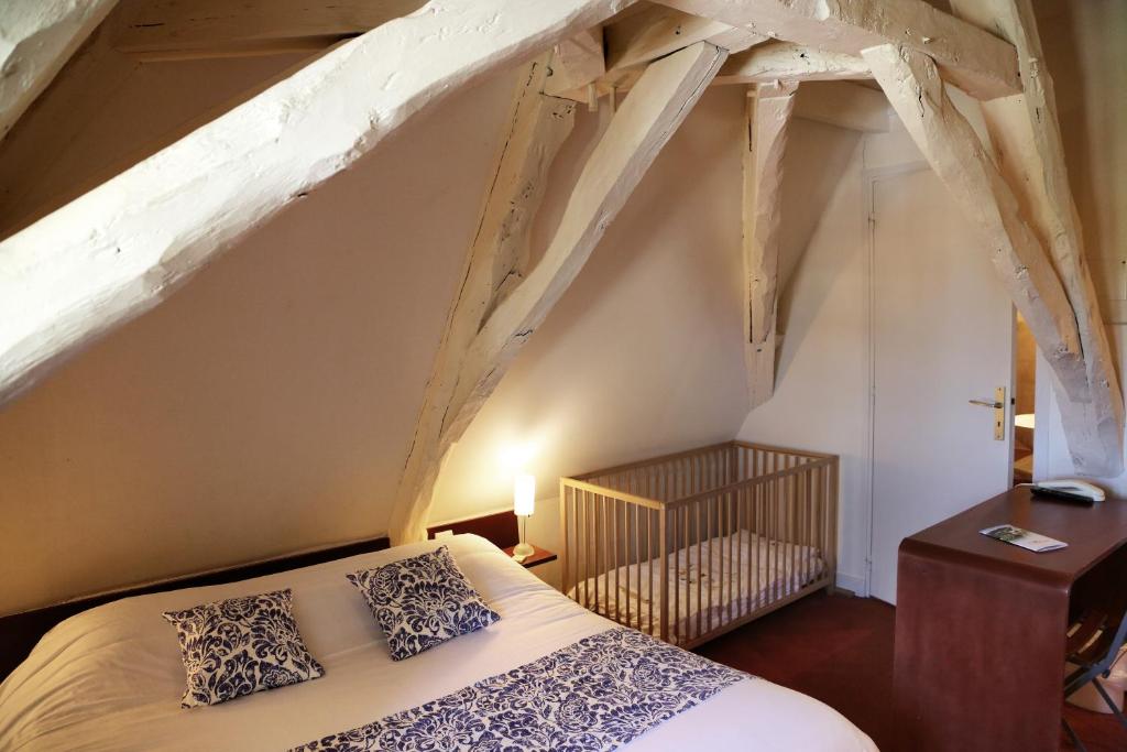ein Schlafzimmer mit einem Bett im Dachgeschoss in der Unterkunft Logis La Garissade in Labastide-Murat