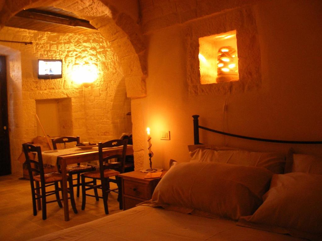 een slaapkamer met een bed en een tafel en stoelen bij Trulli Resort Monte Pasubio Trulli bbalberobellocom in Alberobello