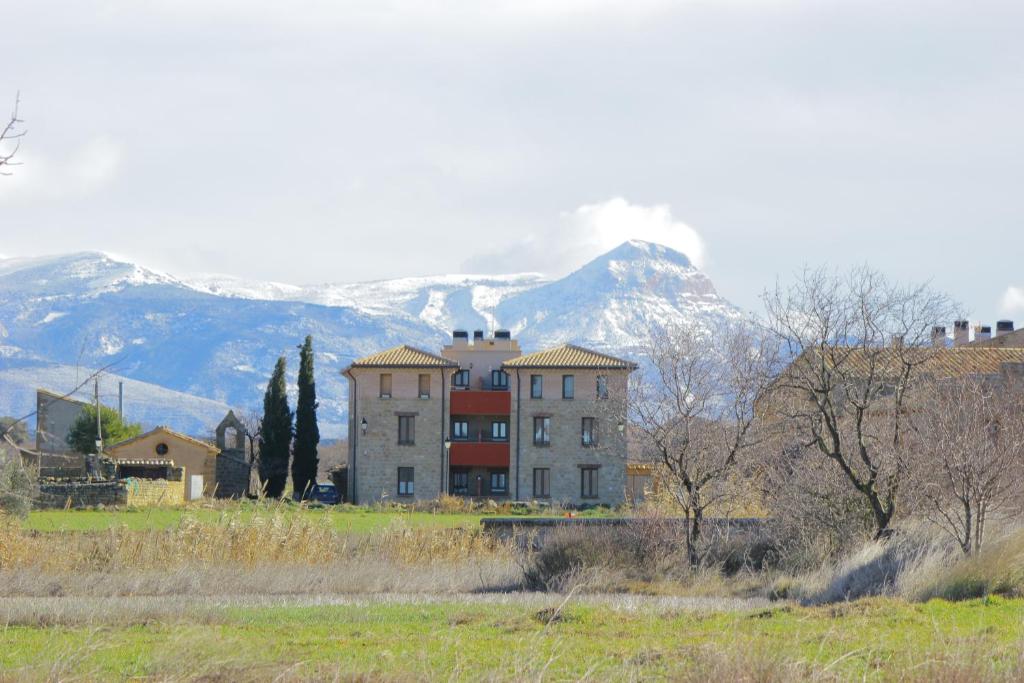 un grand bâtiment en face d'une montagne dans l'établissement Atardeceres d'Aragón, à Fontellas