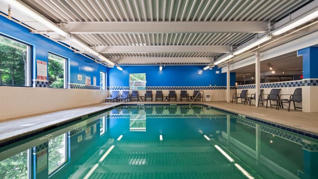 a swimming pool in a building with blue walls at Baymont by Wyndham Groton/Mystic in Groton