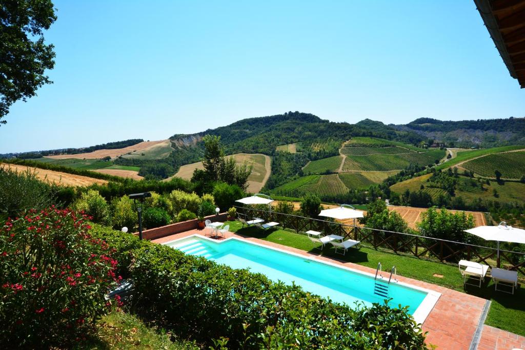 MonteveglioにあるLocanda Gli Uliviの丘の景色を望むスイミングプール