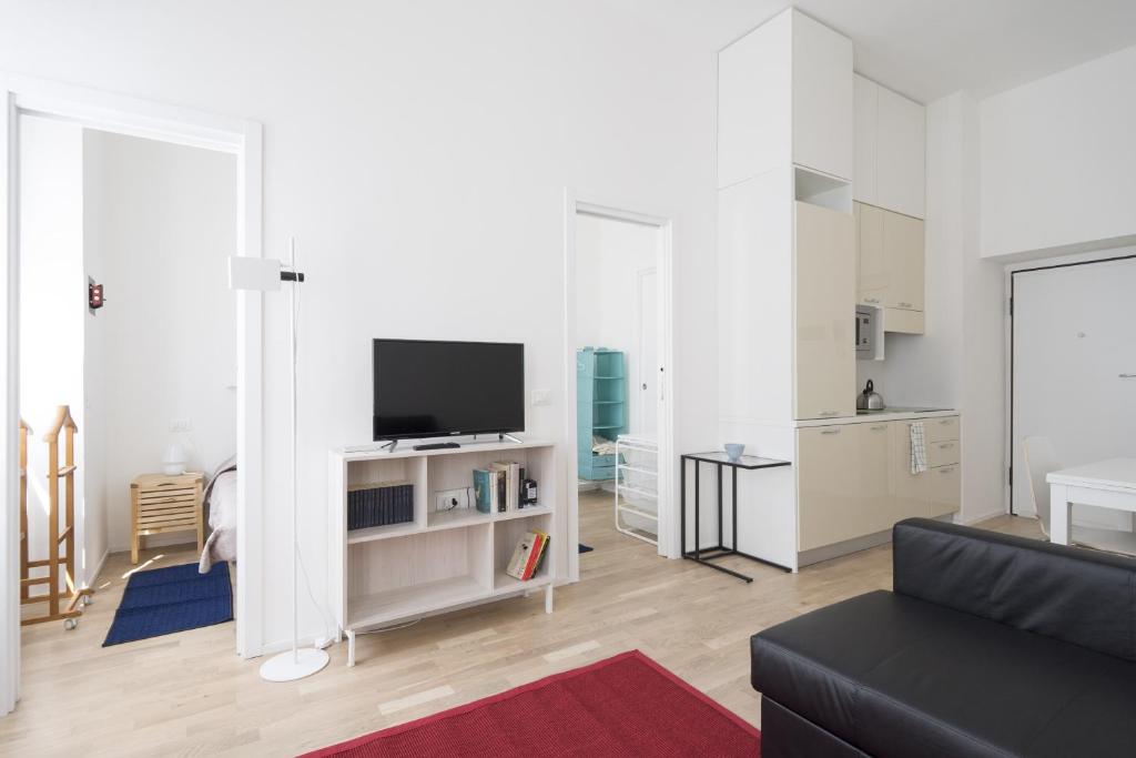 uma sala de estar com um sofá e uma TV de tela plana em PrimoPiano - Astolfo 12 em Milão