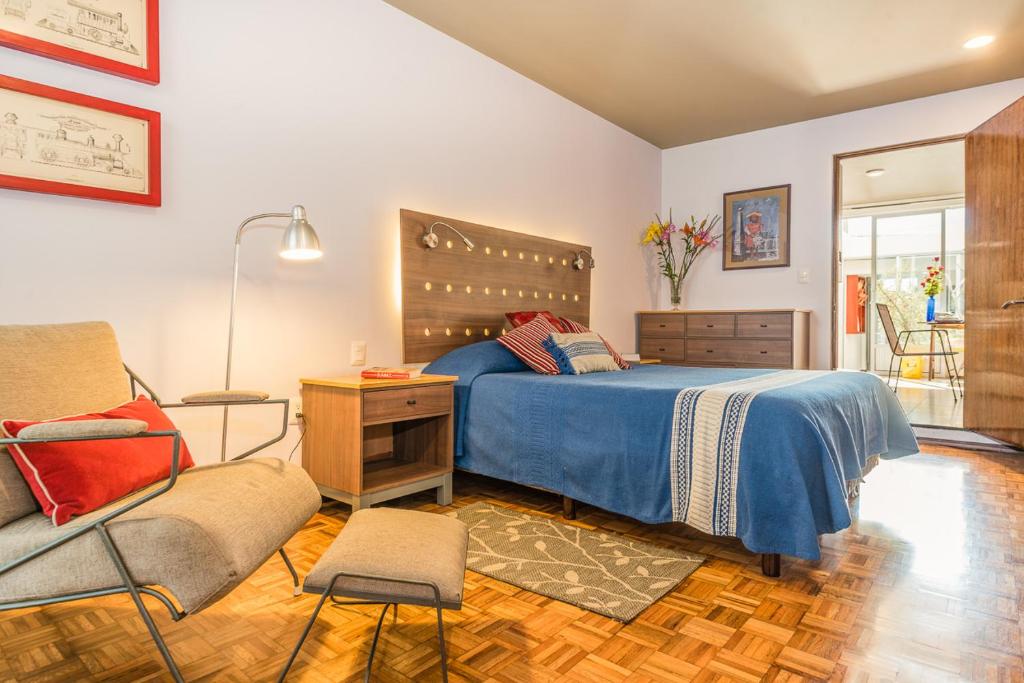 een slaapkamer met een bed, een stoel en een bureau bij Departamento Reforma in Oaxaca City