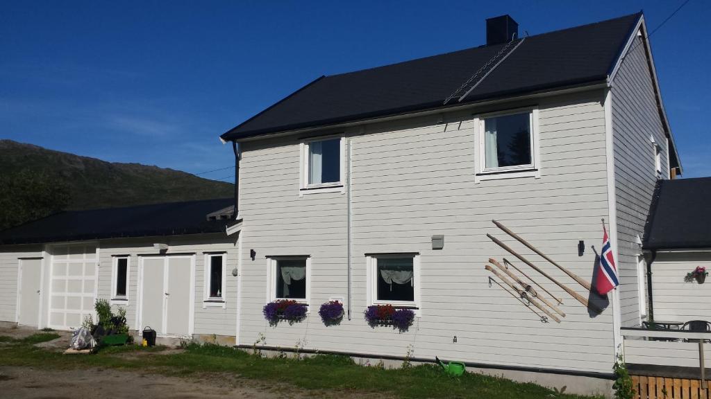 uma casa branca com um telhado preto em Utsikten Feriehus i Bakkeby em Bakkeby