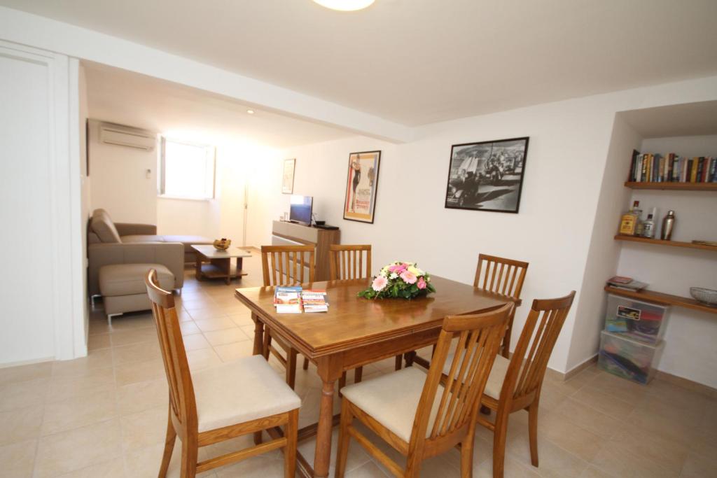 sala de estar con mesa de madera y sillas en Apartment Jacqueline, en Dubrovnik