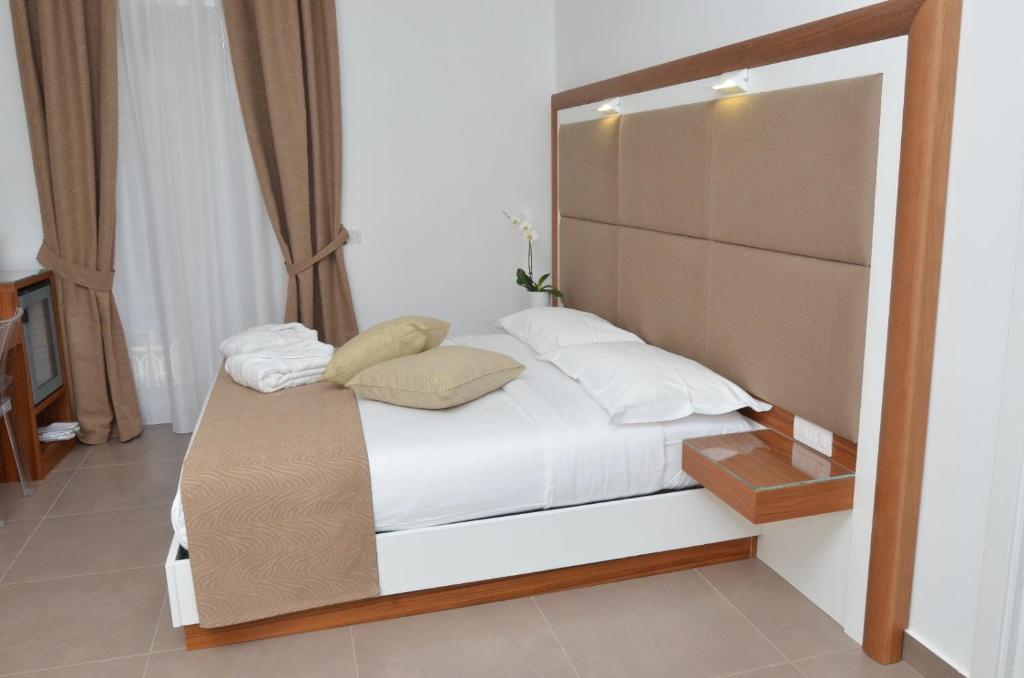 ナポリにあるB&B La Movidaの小さなベッドルーム(白いシーツと枕のベッド付)