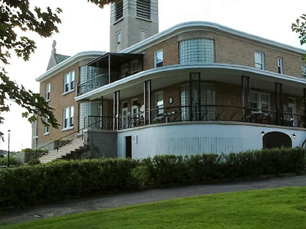 a large building with a tower on top of it at Auberge le St-Georges in Saguenay