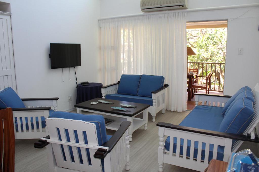 a living room with blue chairs and a table at 41 The Bridge in St Lucia