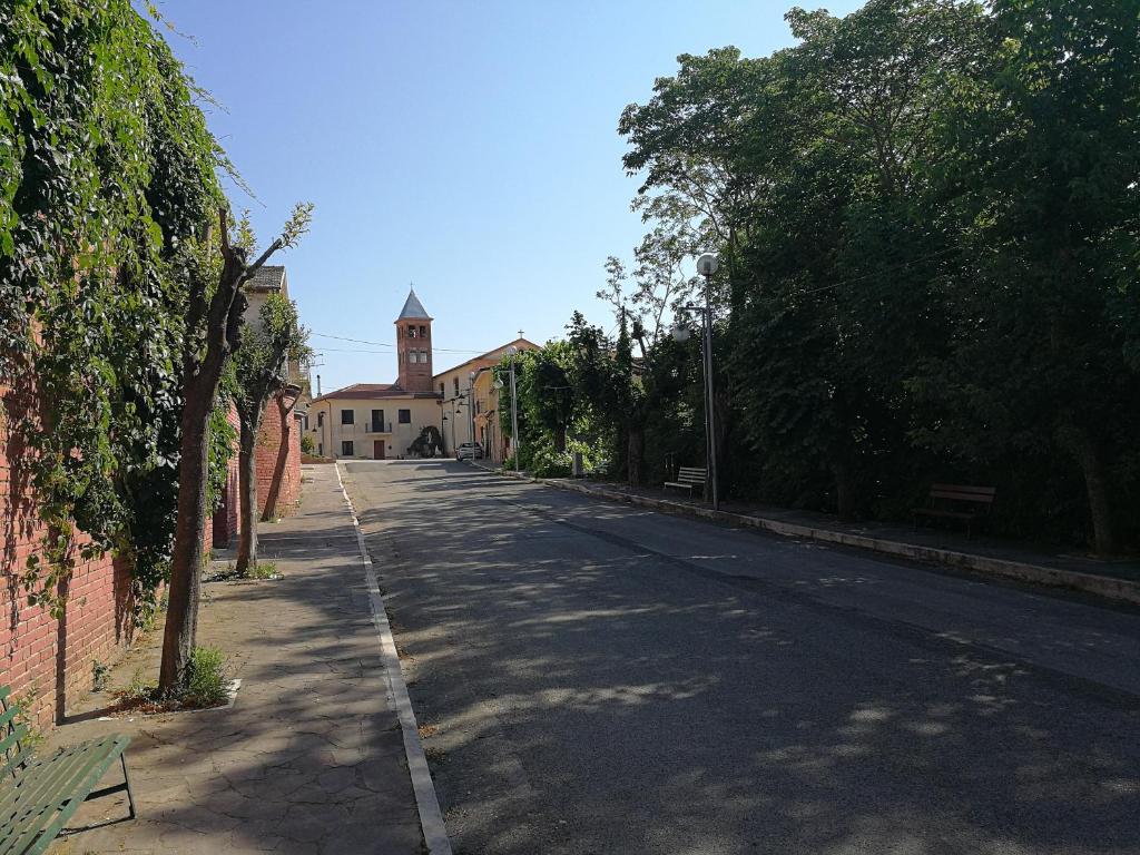 una strada vuota con un edificio e una torre dell'orologio di Grazioso appartamento in San Marco ai Monti a San Nicola Manfredi