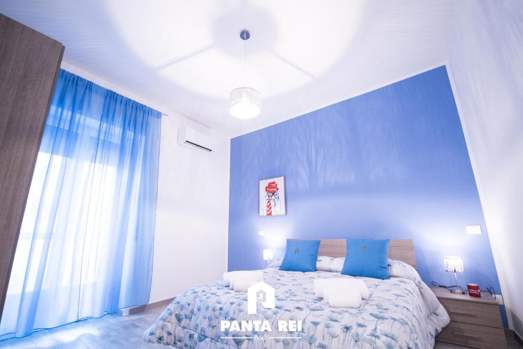a bedroom with blue walls and a bed with blue pillows at Pantarei B&B in Salerno