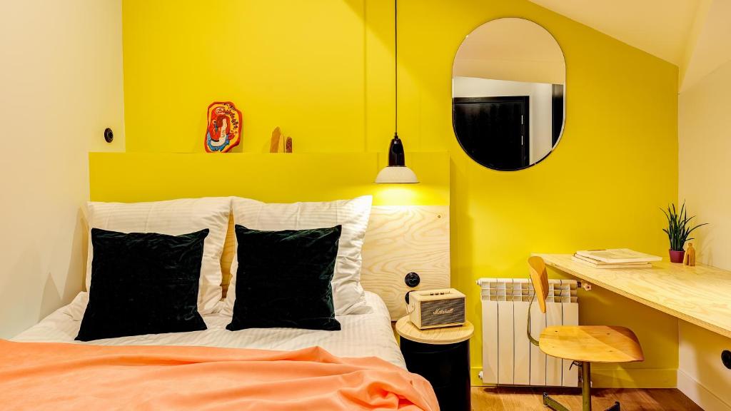 1 dormitorio con paredes amarillas y 1 cama con almohadas negras en Pokrovka 6 Hotel, en Moscú