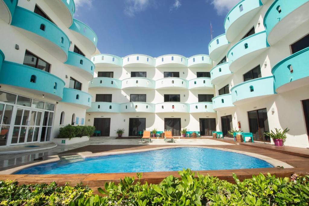 an exterior view of a large apartment building with a swimming pool at Hotel All Riviera in Playa del Carmen
