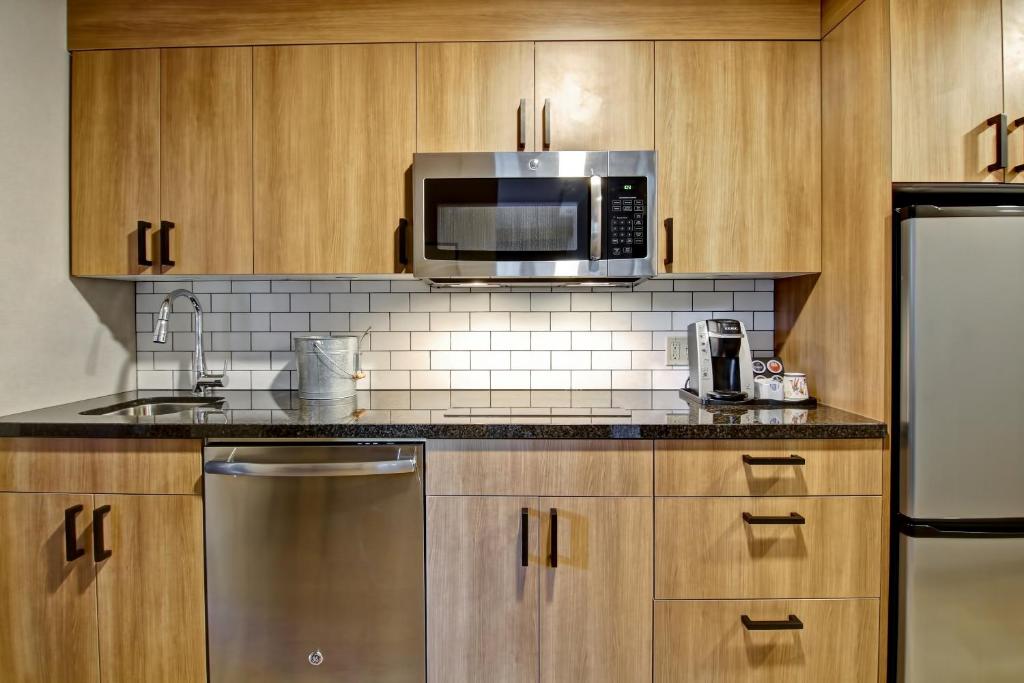 a kitchen with a microwave and a refrigerator at Canalta Lodge in Banff