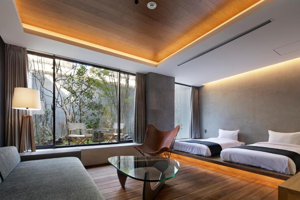 um quarto de hotel com duas camas e uma mesa de vidro em 22 PIECES em Quioto