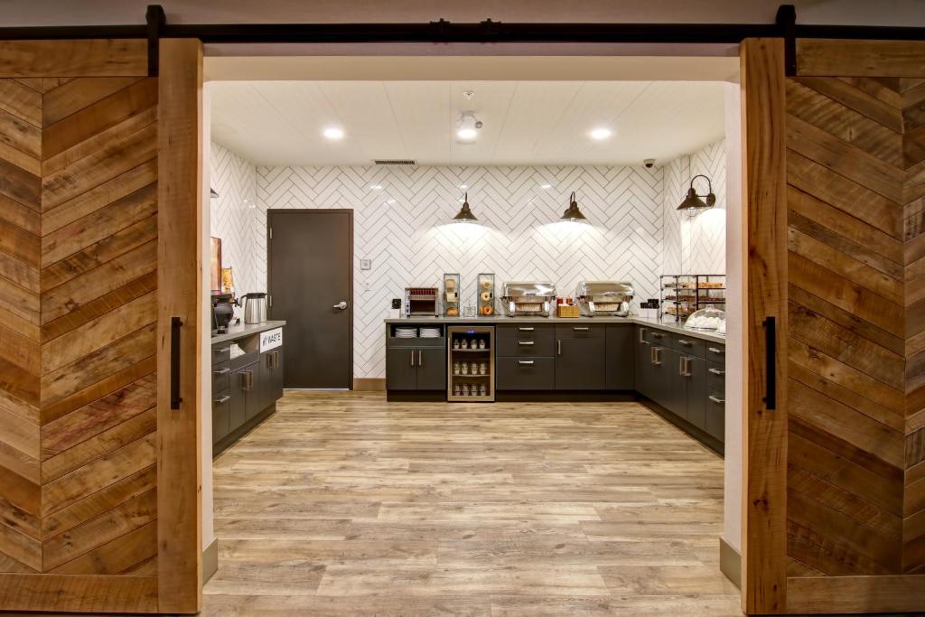 a large kitchen with black cabinets and a wooden door at Canalta Lodge in Banff