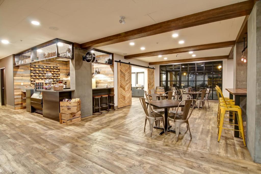 a restaurant with wooden floors and tables and chairs at Canalta Lodge in Banff