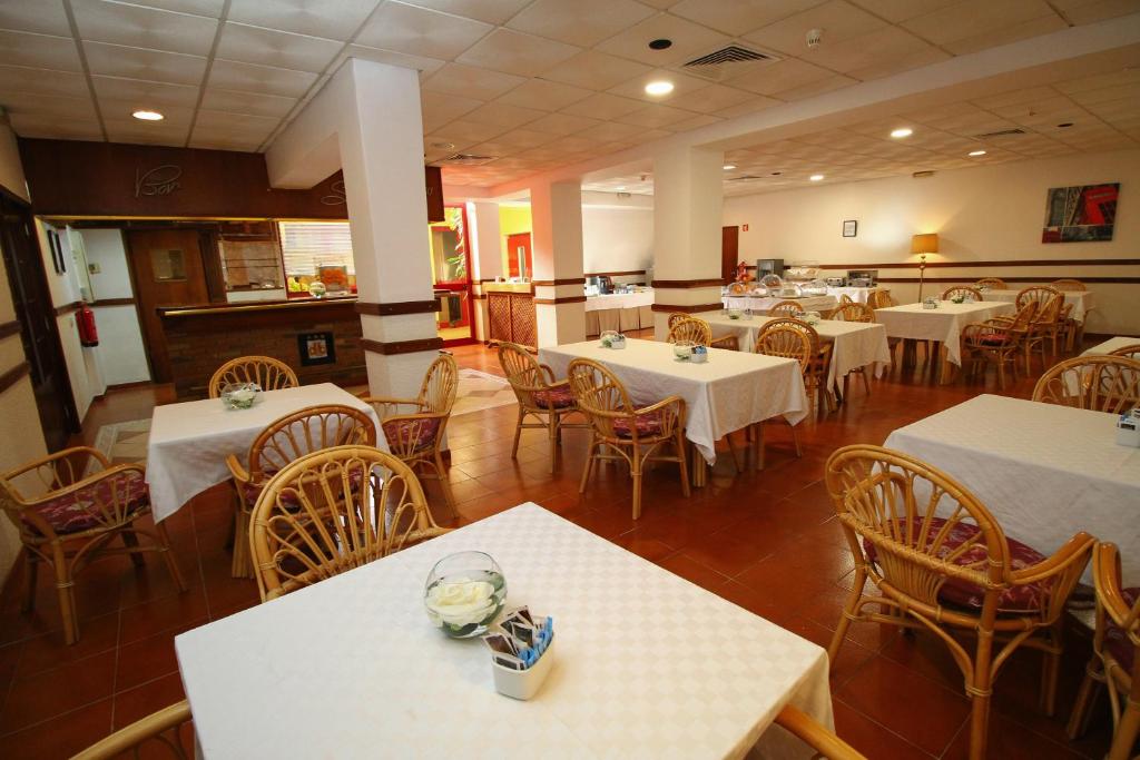 an empty restaurant with white tables and chairs at Best Western Hotel Dom Bernardo in Faro
