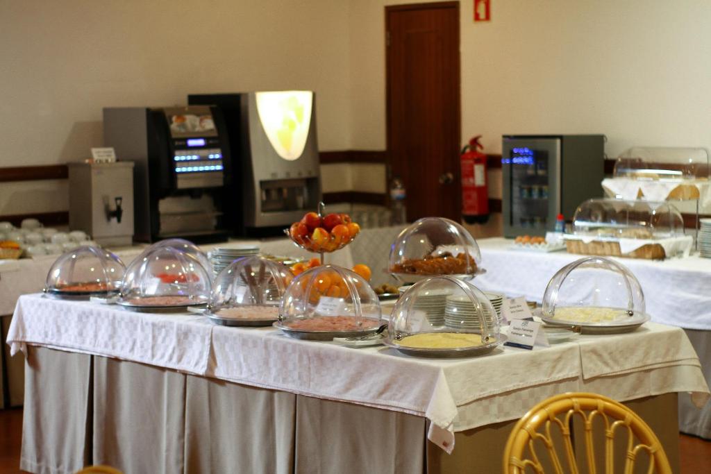 a table with several bowls of food on it at Best Western Hotel Dom Bernardo in Faro