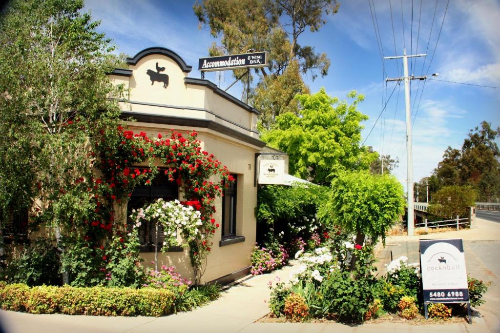 a house with a flower garden in front of it at CocknBull Boutique Hotel Echuca in Echuca