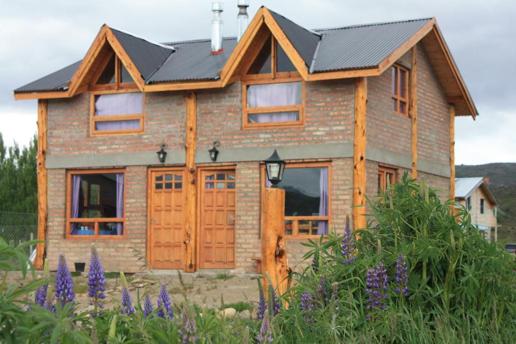 una casa de madera con techo negro en Los Tres Picos en Cholila