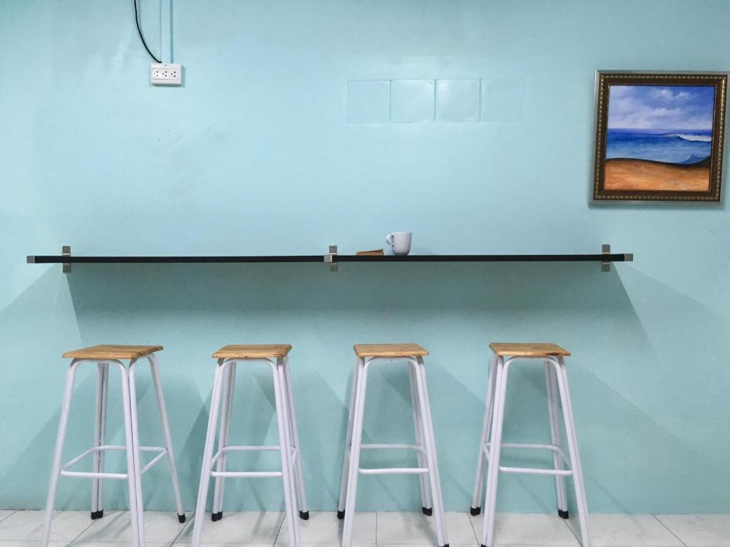 three bar stools in front of a blue wall at Best Rent a Room in Nai Yang Beach