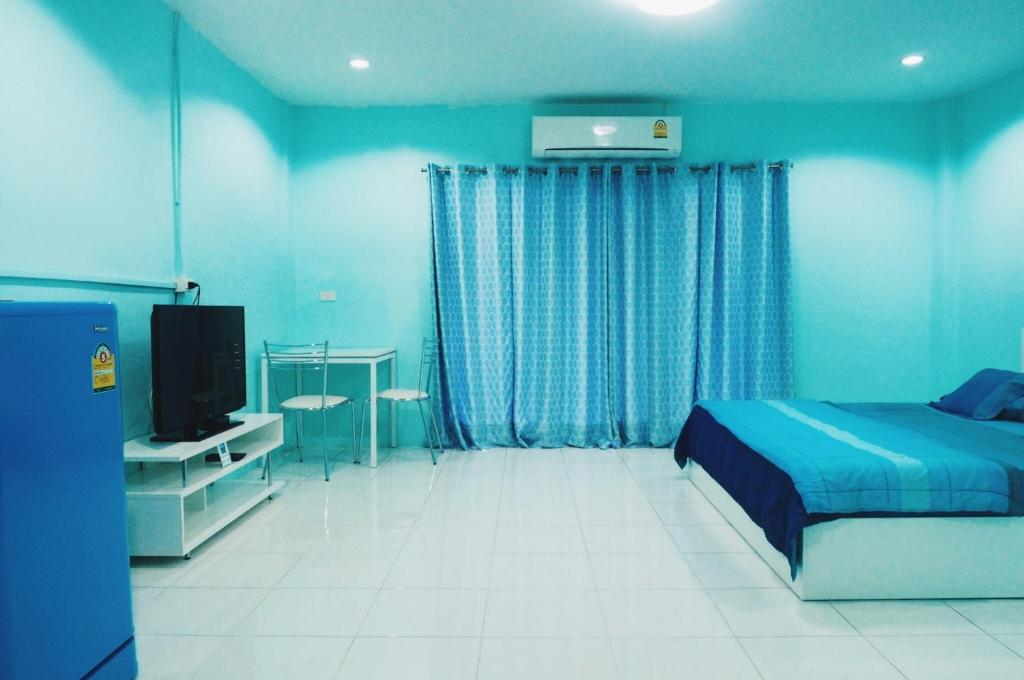 a blue bedroom with a bed and a television at Best Rent a Room in Nai Yang Beach