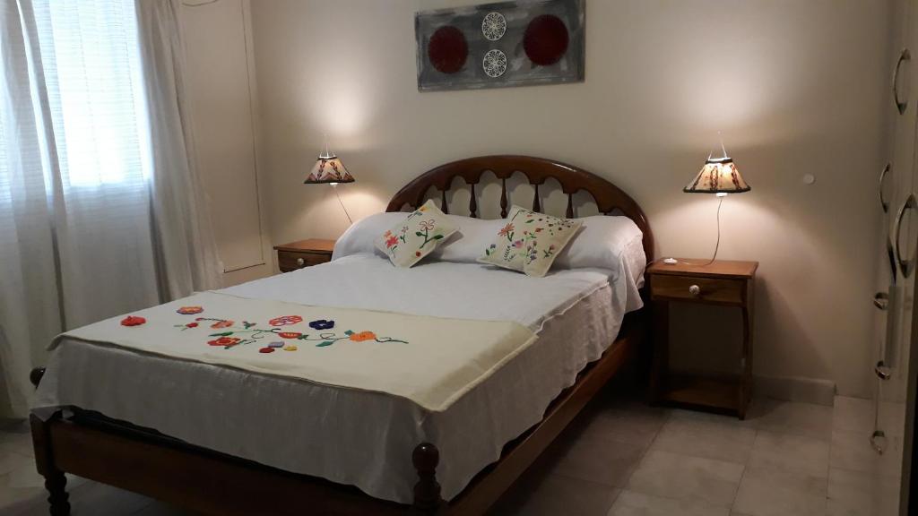um quarto com uma cama com duas mesas de cabeceira e dois candeeiros em Apart Polonia em San Miguel de Tucumán