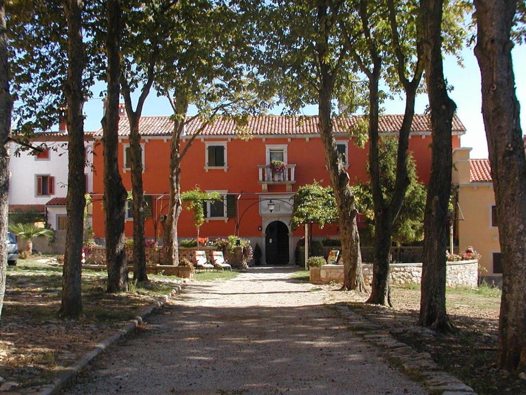 a large orange building with a pathway in front at Apartments Lazzarini Battiala in Nedeščina