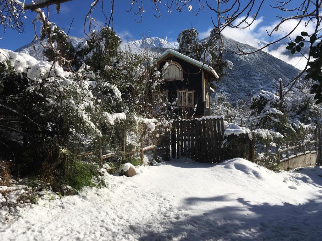 una pequeña cabaña en la nieve con una valla en Loft del Rio, en Cajon del Maipo