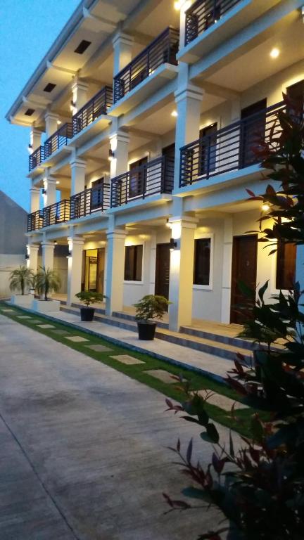 un gran edificio con balcones y plantas delante de él en Veranda Residence Inn en Tacloban