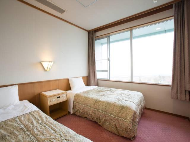 Postel nebo postele na pokoji v ubytování Ikaho Grand Hotel