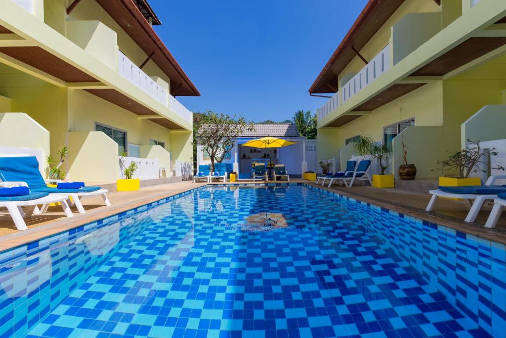 una piscina en una villa con azulejos azules en Baan Chaylay Resort Karon, en Karon Beach