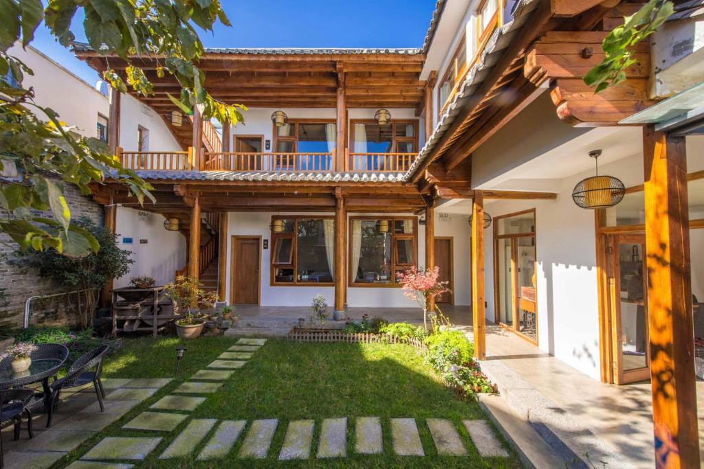 uma casa com um jardim com um pátio em Dali Xian Jing Courtyard Inn em Dali