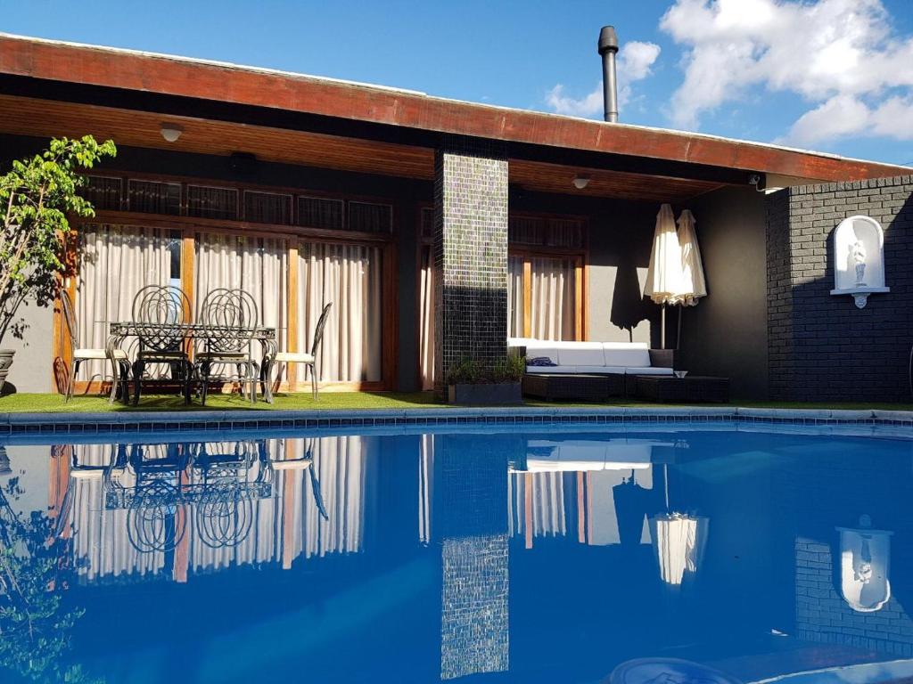 a house with a swimming pool in front of a house at A' Queenslin Guesthouse in Paarl