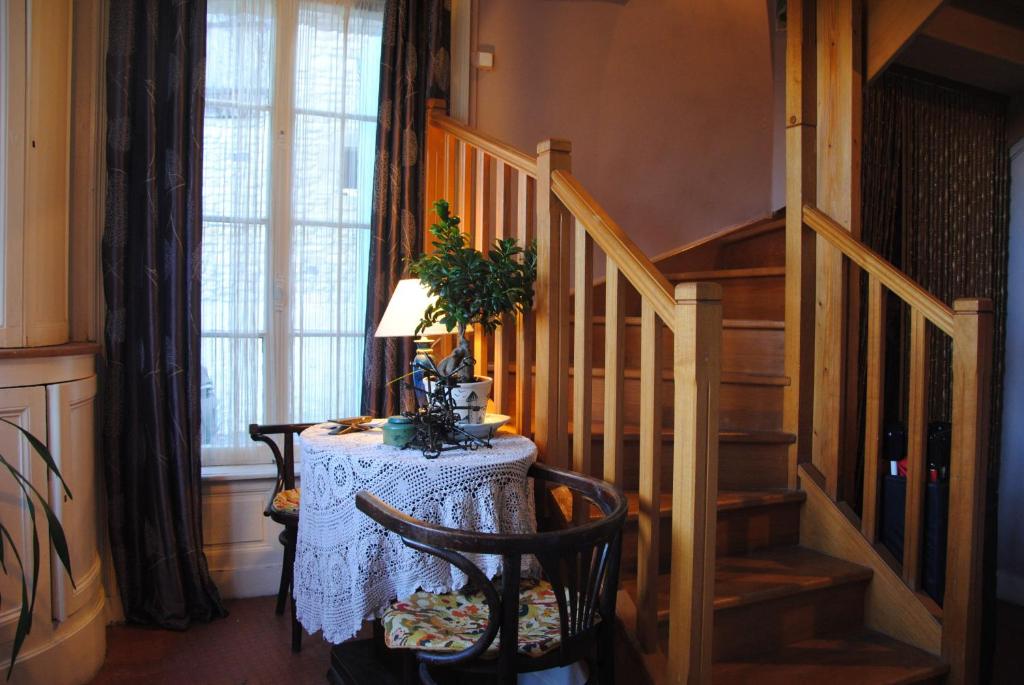 a room with a table with a lamp and a staircase at Chambres Chez Mounie in Arromanches-les-Bains
