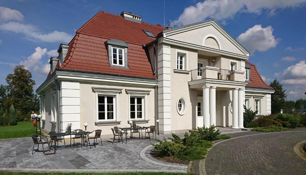 a large white house with a red roof at Eco Nieborów in Nieborów