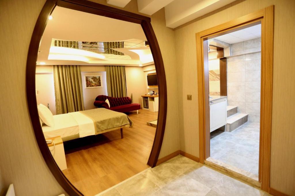 a mirror in a hotel room with a bedroom at Life Corner Hotel in Izmir