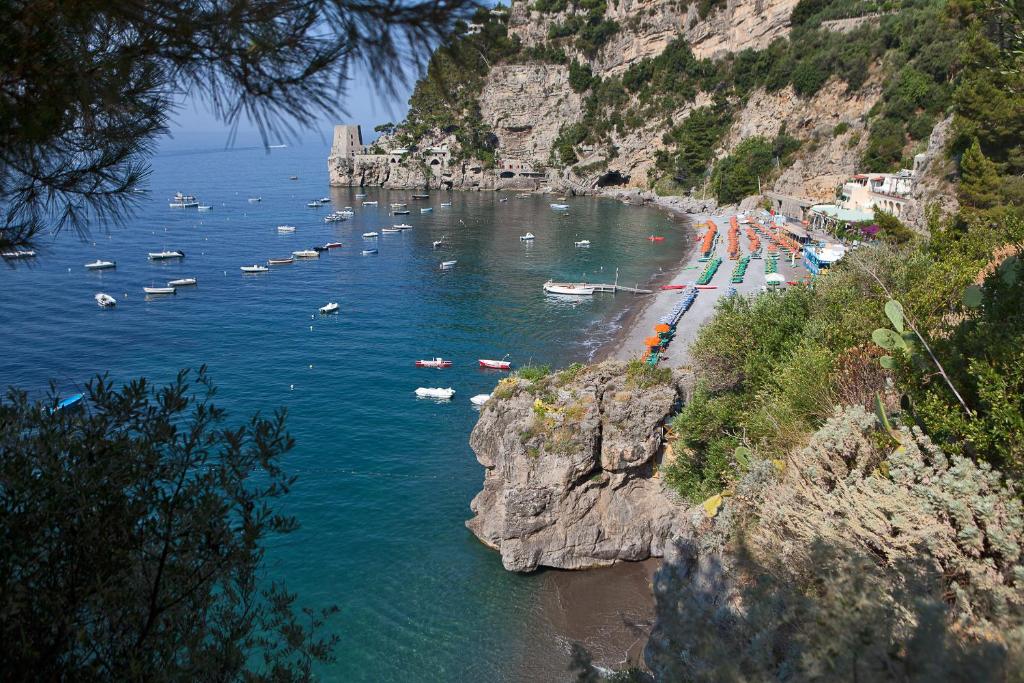 vista su una spiaggia con barche in acqua di Hotel Pupetto a Positano